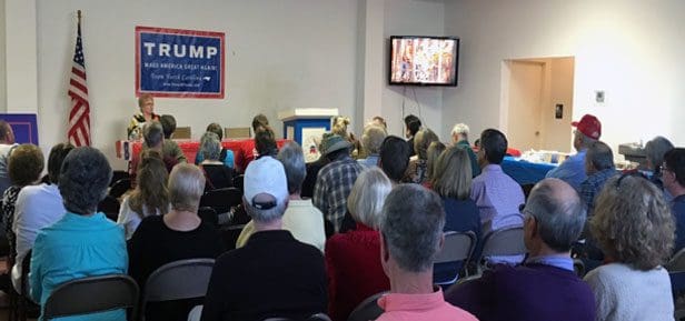 A group of people sitting in front of a tv.