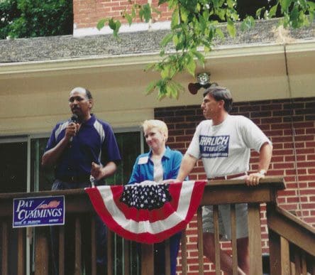 A group of people standing on top of a porch.